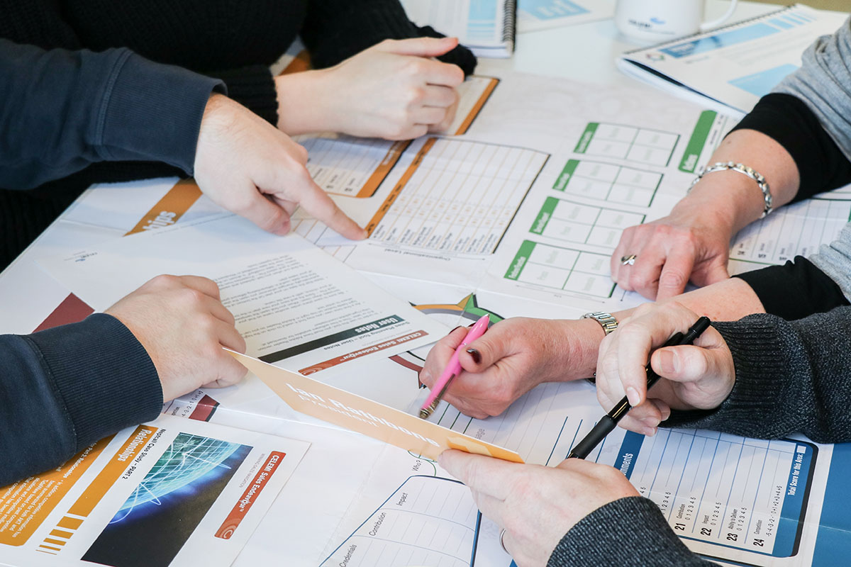 Top view of a group of people playing CELEMI Sales Endeavour™ business simulation