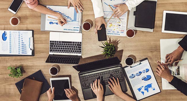 Top view of executive professionals in group meeting with laptop, coffee and document on a table